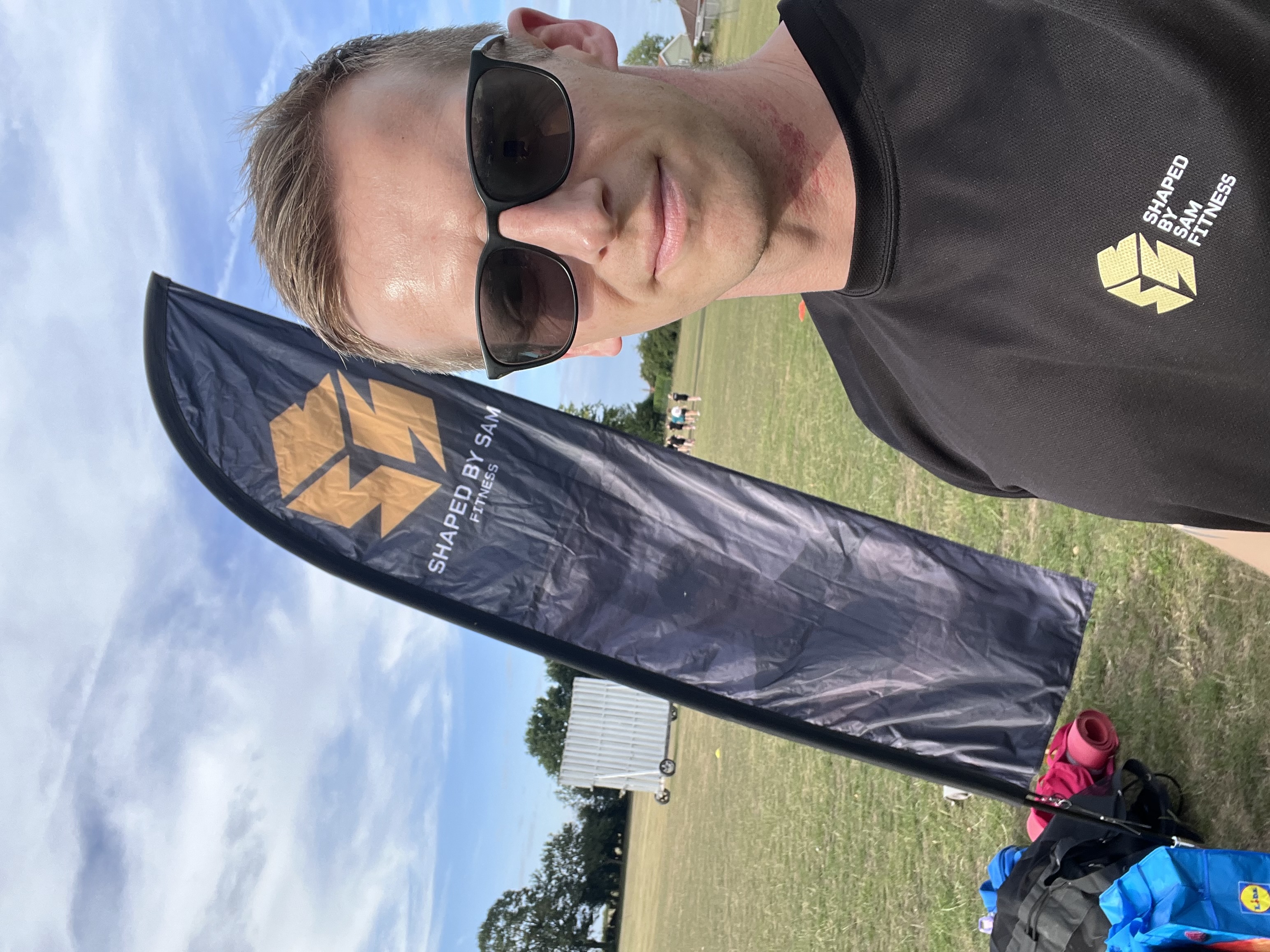 Sam with Shaped by Sam branded flag at boot camp